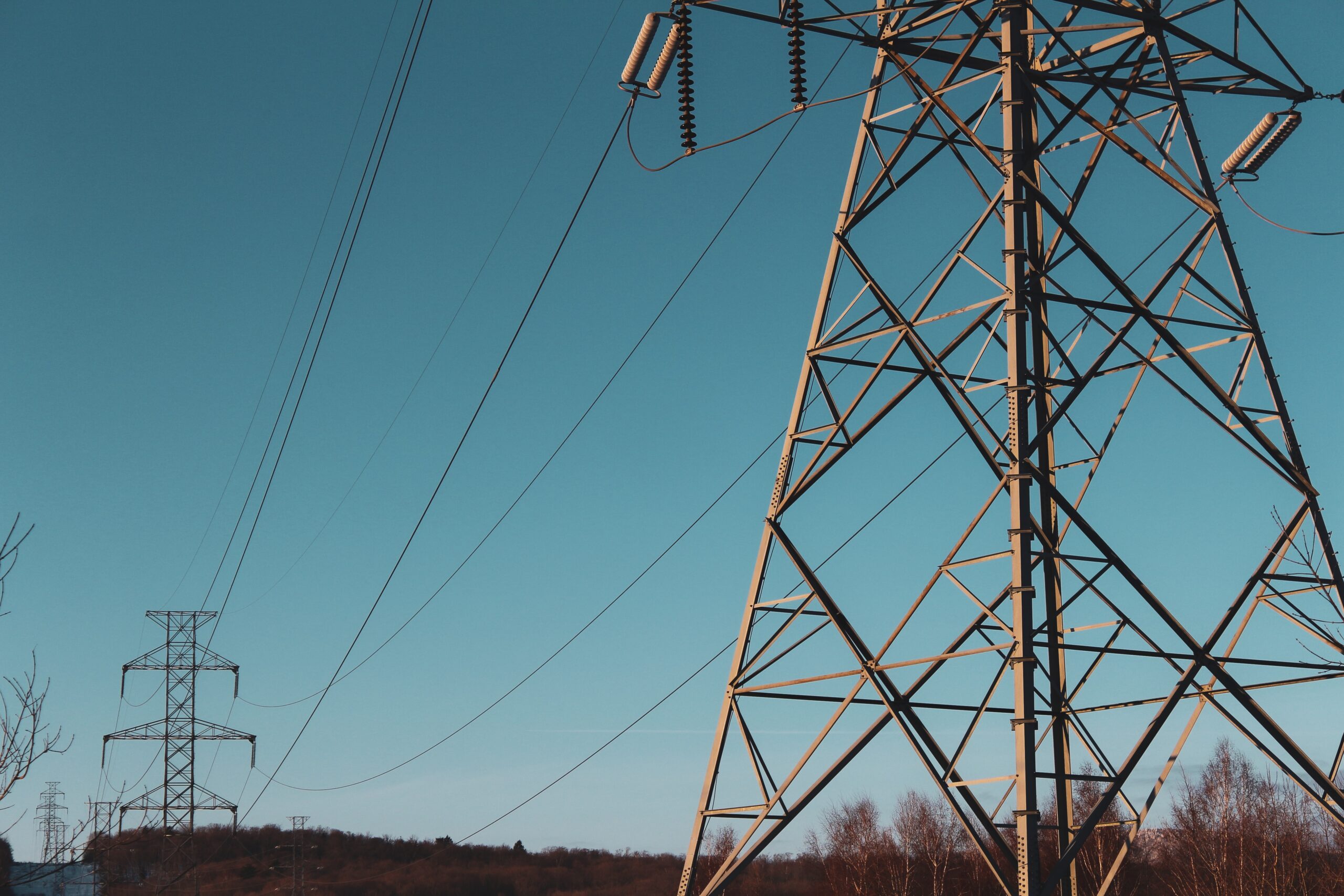 Strommasten vor blauem Himmel. Intelligente Netze können den Netzausbau begrenzen.