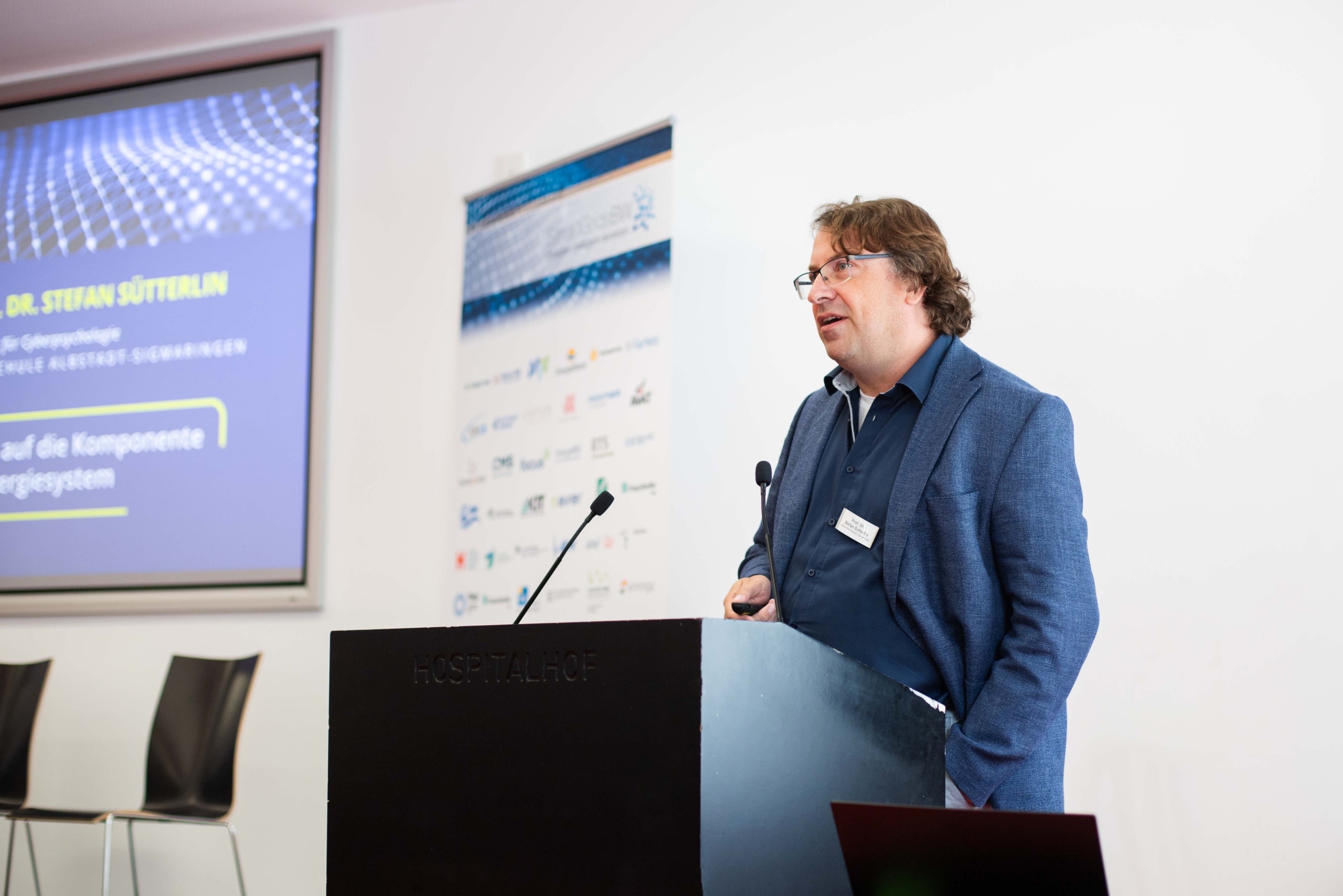 Foto: SmartGridsBW (Lea-Philine Beyer) Smart Grids-Gespräche zum Thema Resilienz: Wie wir kritische Infrastrukturen sichern können. Referent Dr. Stefan Sütterlin am Rednerpult.